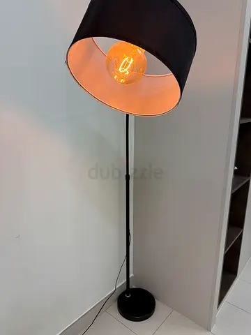 Black floor lamp with fabric shade and exposed filament bulb