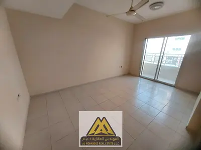 Large 2BR with separate living room in Al Nuaimiya 2, 2 baths, balcony, central AC, free maintenance.