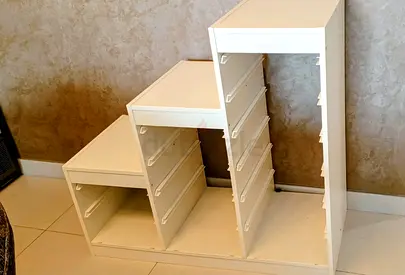 White stepped storage cabinet with drawer rails — good condition