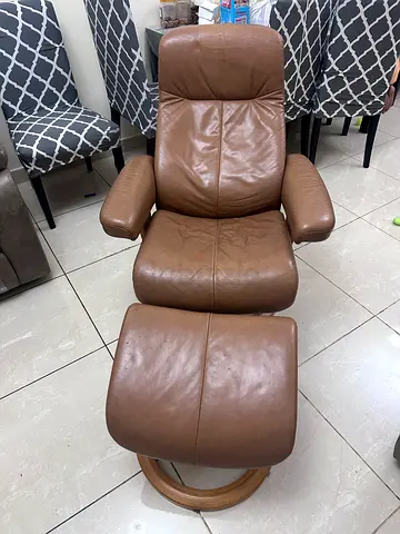 Brown leather recliner armchair with ottoman. Average condition