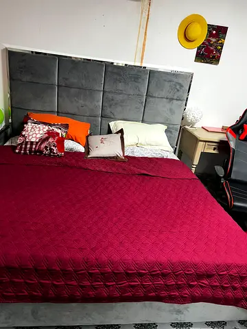 Grey King size bed frame with padded headboard and mattress with two grey side tables/nightstands