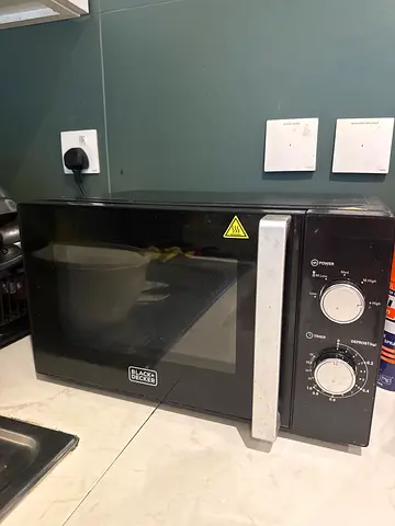 Black countertop microwave oven with manual dials - good working condition