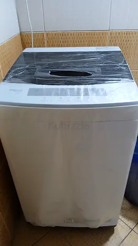 White top load washing machine with digital display. SUPER GENERAL
