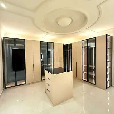 Modern built-in wardrobe with central island and glass display panels