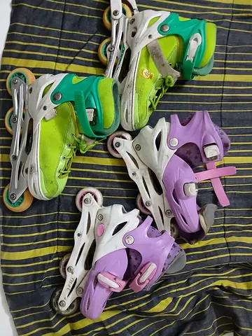 Two pairs of adjustable kids inline skates (green + purple) – used