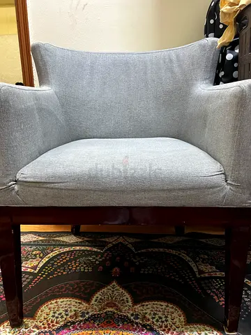 Grey upholstered single armchair with wooden frame