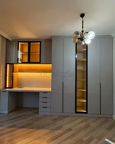 Built-in wardrobe with integrated desk and illuminated shelving