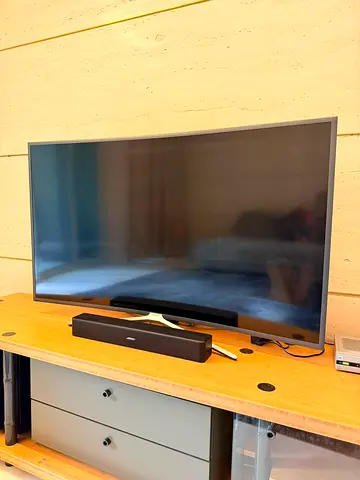 Samsung smart TV with soundbar and entertainment unit