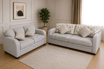 Pair of light grey sofas with floral back cushions