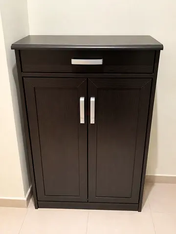 Dark brown wood shoe cabinet with drawer and shelves having compact storage.