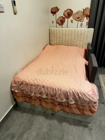 Comfortable Bed Frame with Padded Headboard and Pink Quilted Bedding