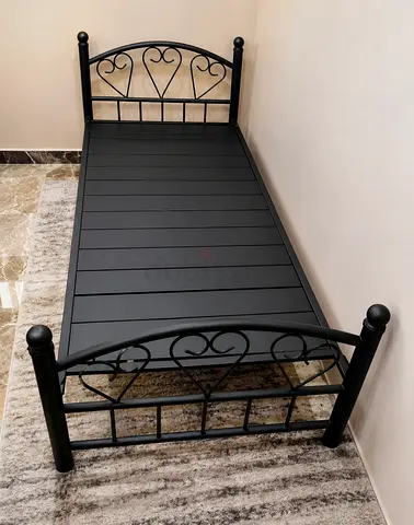 Single black metal bed frame with decorative headboard and footboard