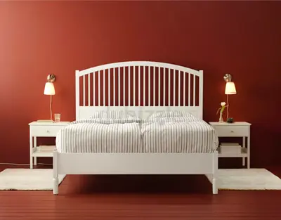 White wooden double bed with slatted headboard and two bedside tables