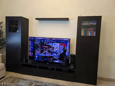 IKEA dark wood entertainment center with two tall cabinets and TV unit