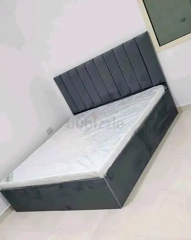 Grey upholstered queen size bed with medical mattress