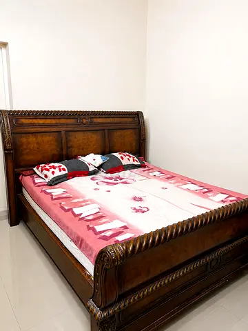 Elegant carved wooden bed with a clean comfortable mattress, offering a luxurious classic look