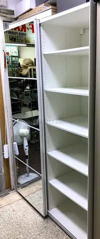 Tall white shelving unit with mirrored sliding door — good condition