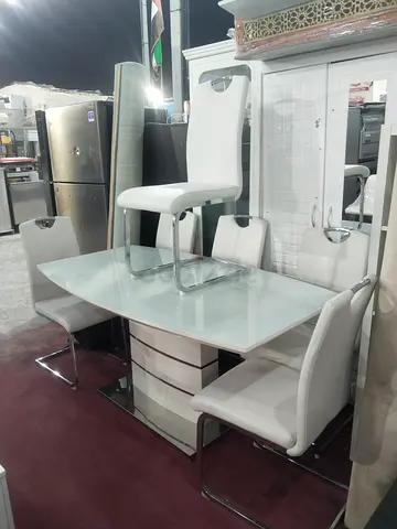 White glass-top dining table with 4 modern chairs