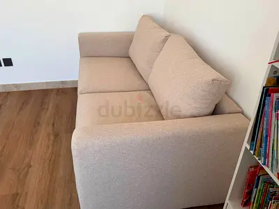 Compact 2-seater beige fabric sofa bed in good condition