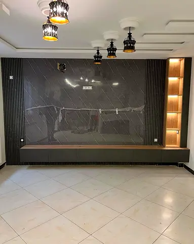 Built-in entertainment wall unit with marble finish and illuminated shelving
