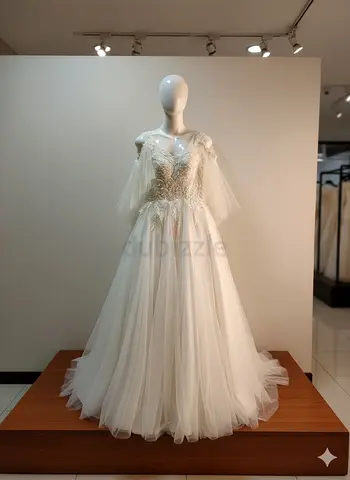Ivory tulle wedding gown with lace bodice and cape sleeves