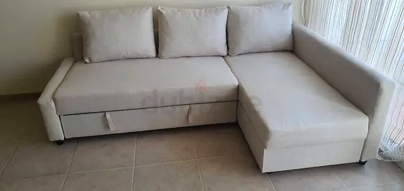 Light beige L-shaped sofa bed with storage — good condition