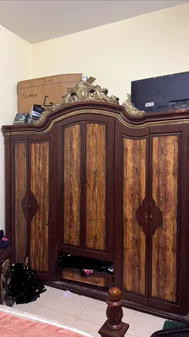 A king-size bed in good condition with a three-door wardrobe and a free dresser.