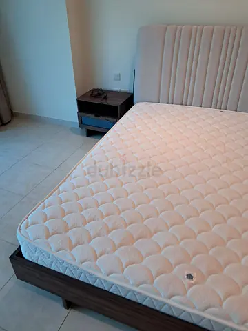 King bed frame with mattress and bedside table