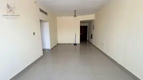 Two bedrooms and a living room with a balcony and central air conditioning in Al Rashidiya