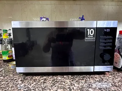 Samsung countertop microwave with 10-year warranty sticker - good condition