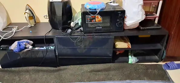 Low black TV entertainment unit with shelves and drawers - used