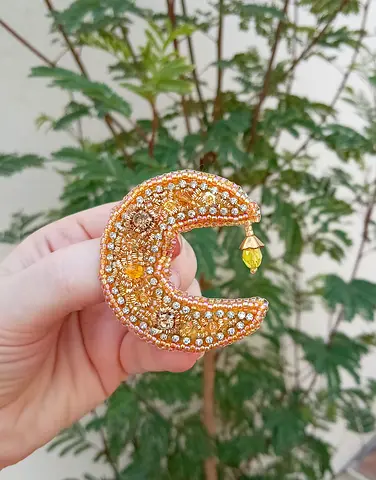 Hand-embroidered crescent moon brooch with beads and charm