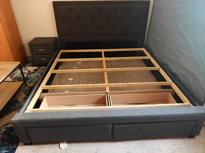 Gray fabric queen bed frame with storage drawers and headboard