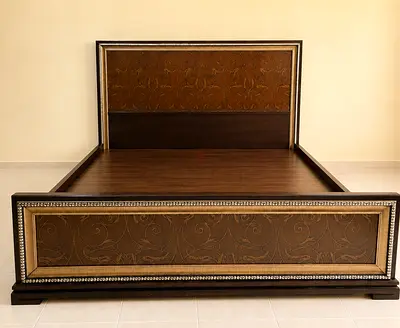 Super King size wooden bed frame with carved headboard and footboard.
