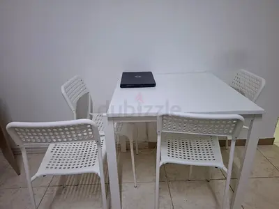 White dining table with 4 matching plastic chairs - simple set