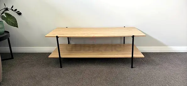 Simple two-tier wooden coffee table with black legs - good condition