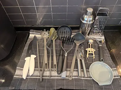 Assorted kitchen utensils set — knives, ladles, peelers, grater, cocktail shaker