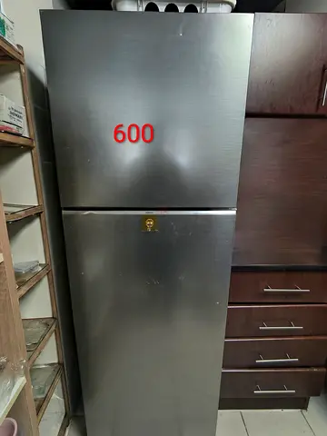 Silver top-freezer refrigerator in good working condition - 600 AED