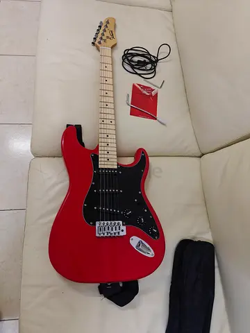 Red electric guitar (Strat-style) with case, cable and strap - good condition