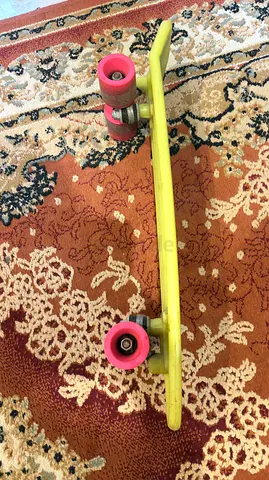 Yellow mini cruiser skateboard with pink wheels -