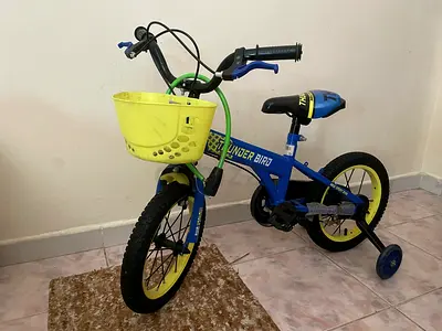 Blue kids' bicycle with training wheels and front basket - good condition
