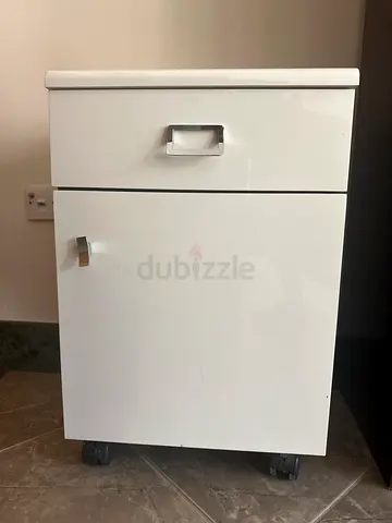 Compact white table with drawer and cupboard on wheels