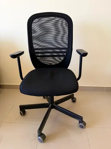 Black mesh ergonomic office chair with armrests and wheels