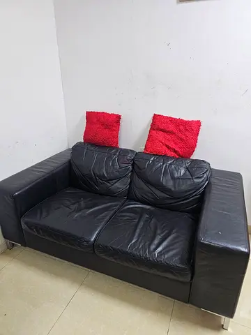 Black leather 2-seater sofa with ottoman - good condition
