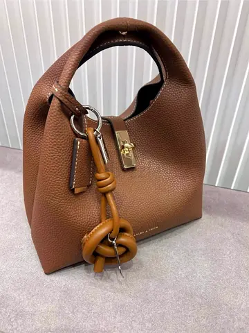 Brown leather bucket handbag with gold lock and knot charm
