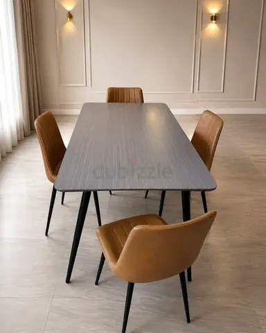 Modern dining table with four tan upholstered chairs
