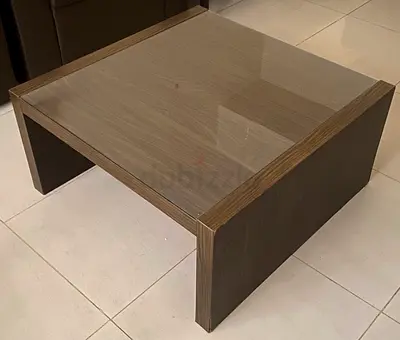 Low modern wooden coffee table with glass top