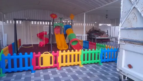Outdoor kids playground set with slide, tunnel, swings and safety fence