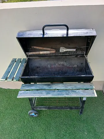 Used charcoal BBQ grill with wheels and folding side shelf