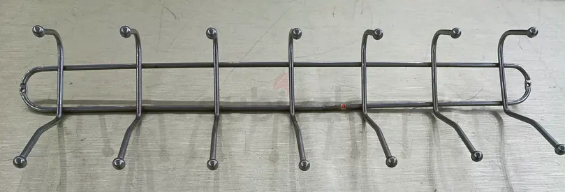 Wall-mounted stainless steel coat and hat rack with 7 double hooks.